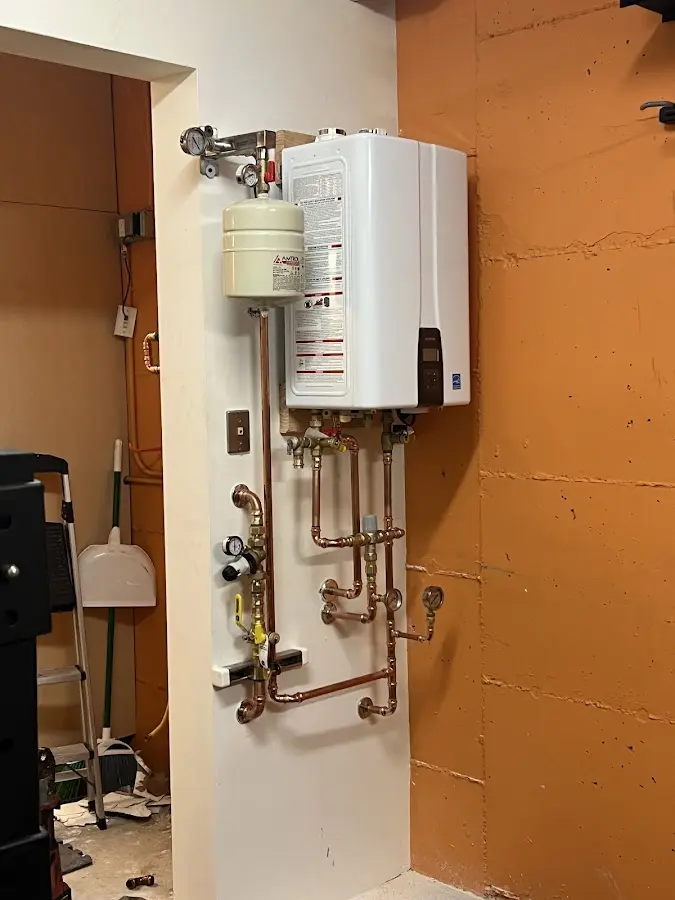 Plumbing technician inspecting water heater connections in Yoakum
